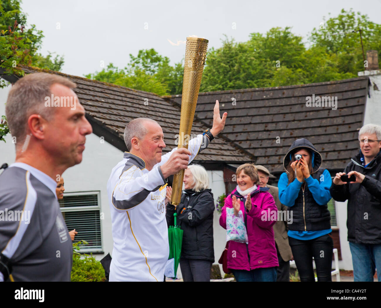 Venerdì 8 Giugno 2012. North Ayrshire, in Scozia, Regno Unito. Thomas Tracey, 59, una carità maratoneta da Glasgow, porta la Fiamma Olimpica attraverso il villaggio di Barrmill nel North Ayrshire, in Scozia, Regno Unito Foto Stock