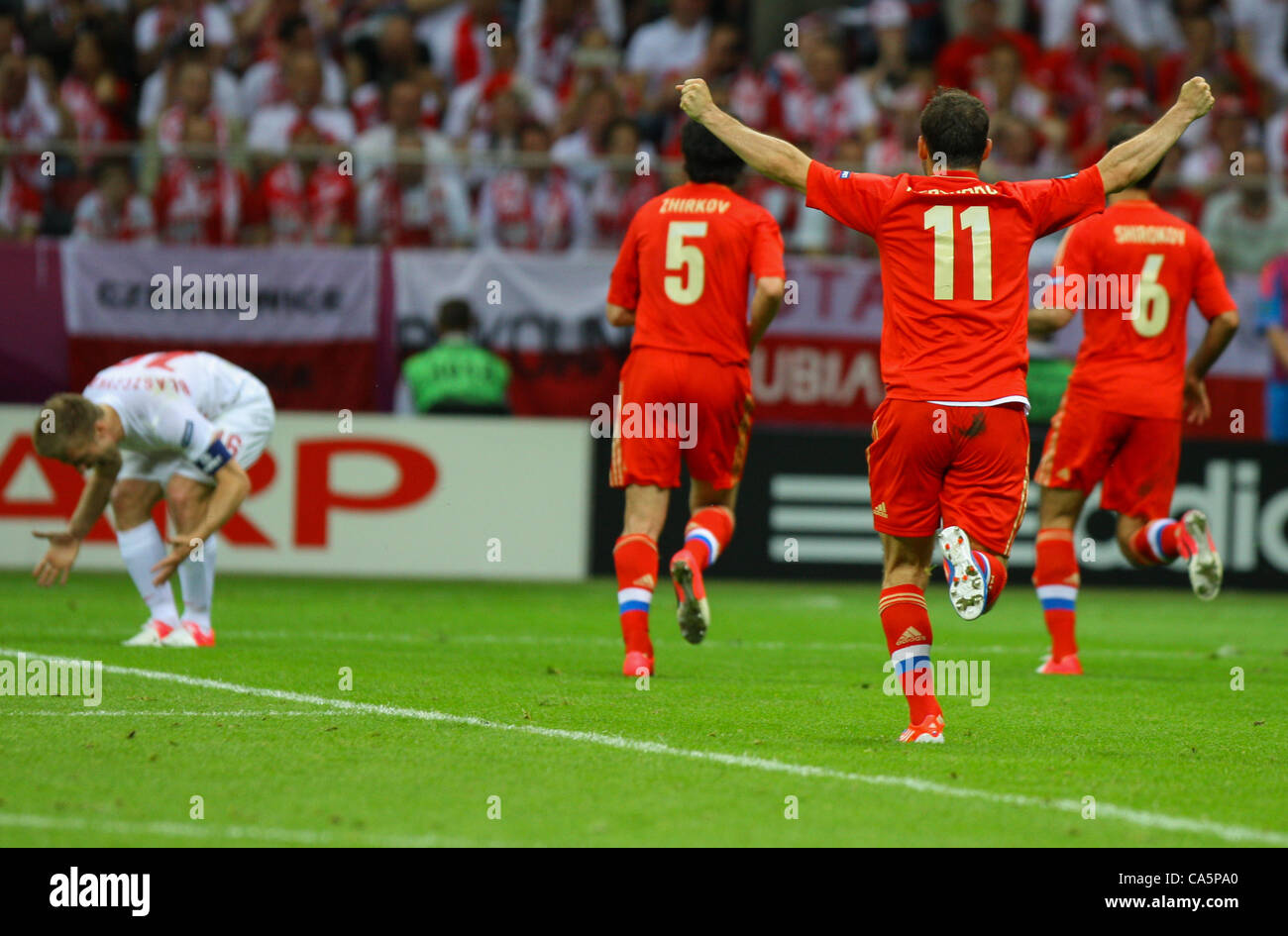 12.06.2012. Varsavia POLONIA UEFA Campionato Europeo 2012 in Polonia e Ucraina Group stage Polonia vs Russia. JAKUB BLASZCZYKOWSKI (POL)sconsolato mentre YURI ZHIRKOV, ROMAN SHIROKOV e ALEKSANDR KERZHAKOV (RUS)celebrano il loro obiettivo di apertura Foto Stock