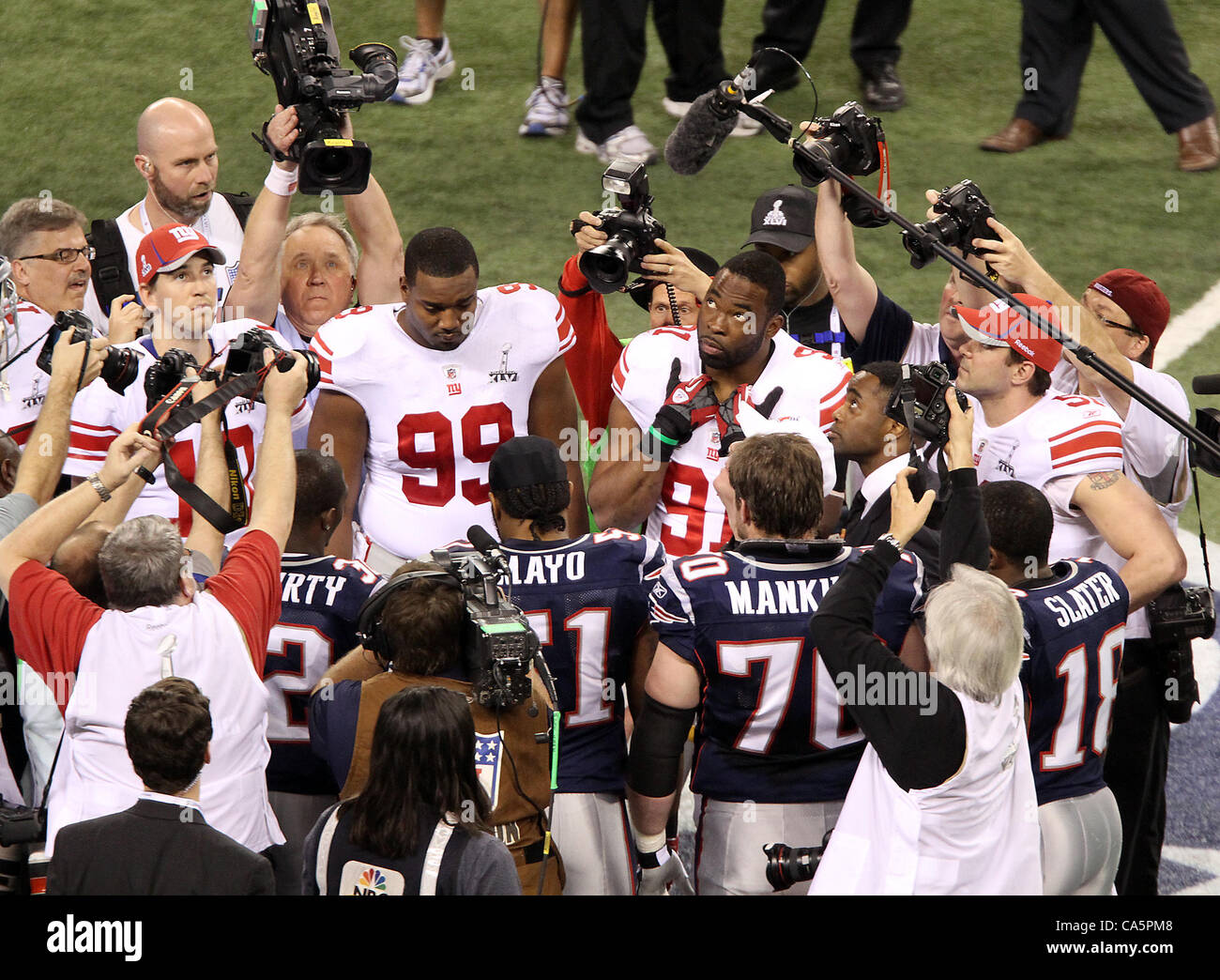 Febbraio 5, 2012 - Indianapolis NEGLI STATI UNITI - New York Giants capitani compresi (L-R) quarterback Eli Manning #10 e difensiva affrontare Chris collocati #99 e difensivo fine Justin Tuck 91guarda il coin toss. Super Bowl XLVI è venuto giù per i secondi finali come New York Giants battere il New England Patriots Foto Stock