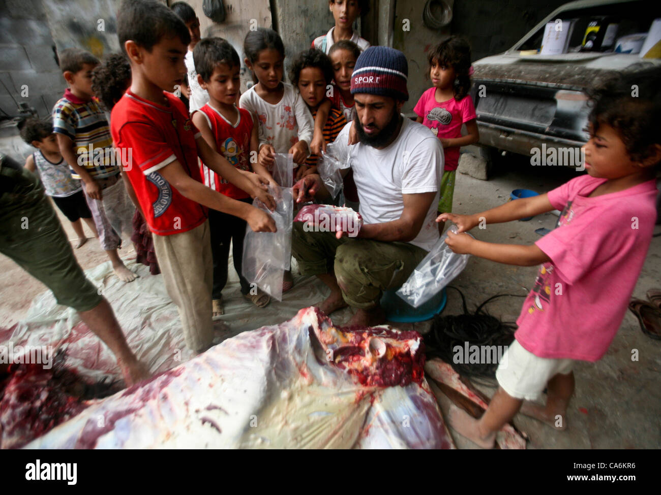 Giugno 15, 2012 - Gaza City, nella Striscia di Gaza, Territori palestinesi - bambini palestinesi ricevono borse di cavallo si incontrano in un quartiere povero nella zona centrale della striscia di Gaza il 15 giugno 2012. La gente del quartiere povero nel centro della striscia di Gaza cavalli da macello ogni venti giorni, e distribuirlo ai Foto Stock