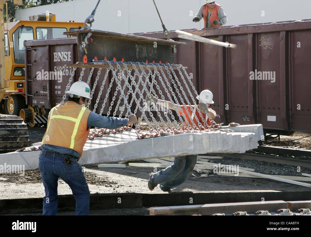 (Pubblicato il 1/19/2005, NC-1, NI-1) Baltazar Tena (sinistra) e Pedro Coombs calcestruzzo posizione di traversine ferroviarie martedì vicino all'intersezione di West Washington Ave. e Hale Ave. in Escondido. Le fascette sono per lo sprinter progetto. I vincoli sono stati scaricati dal veicolo ferroviario in background. UT foto di Edu Foto Stock