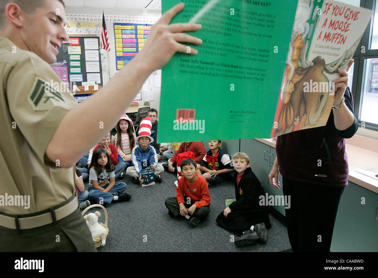 Ce read253400x001 3-2-2006 San Marcos, CA.  Cpl. MICHAEL CHOATE, sinistra e insegnante Maria JO MARTINEZ, destro, leggere un libro per la seconda e la terza sulle livellatrici a Paloma Scuola Elementare di giovedì a San Marcos, CA. L evento è stato parte della lettura annuale in tutta l'America evento presso la scuola.    EDUARDO CONTRERAS/S Foto Stock