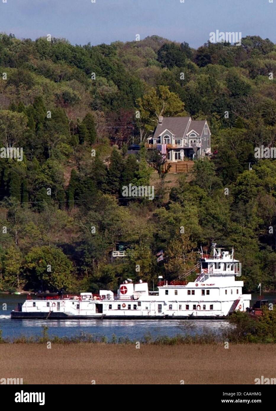 Jul 01, 2003 - Patriota, Indiana, Stati Uniti d'America - un towboat scivola giù il fiume Ohio passando un Kentucky hillside homesite. Oltre 239 milioni di tonnellate di merci sono trasportate su chiatte annualmente sul fiume Ohio. Un tipico 15 chiatta può trainare il trasporto del carico equivalente di 870 semi-camion. (Credito Immagine: Â© Foto Stock