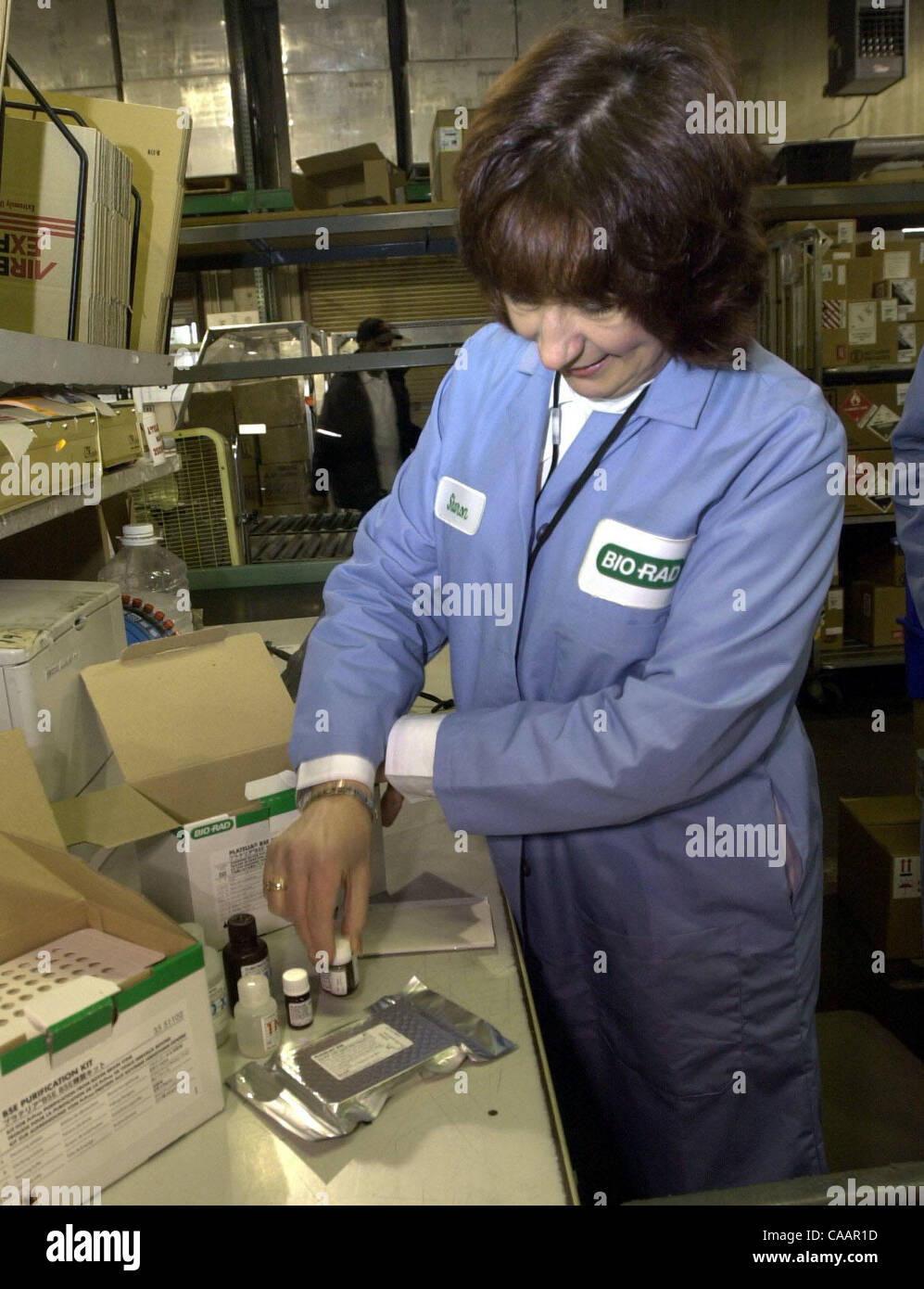 Sharon Llewellyn, distribuzione domestica al supervisore Bio-Rad Laboratories, mostra il contenuto di un Platelia Encefalopatia Spongiforme Bovina test presso la società del magazzino in Richmond, Calif., giovedì 8 gennaio, 2004. Bio-Rad ha 20.000 della malattia della mucca pazza i kit di prova a portata di mano nel caso in cui essi sono n Foto Stock