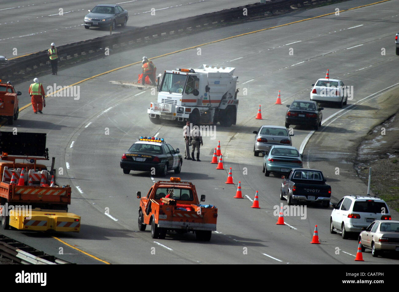 Il traffico è limitato a una corsia mentre gli equipaggi Caltrans ripulire il contenuto rimanente da un camion rovesciato su autostrada westbound 24 appena ad ovest del Caldecott in tunnel di Oakland, California, giovedì 6 febbraio 2004. (Dean Coppola/Contra Costa Times) Foto Stock