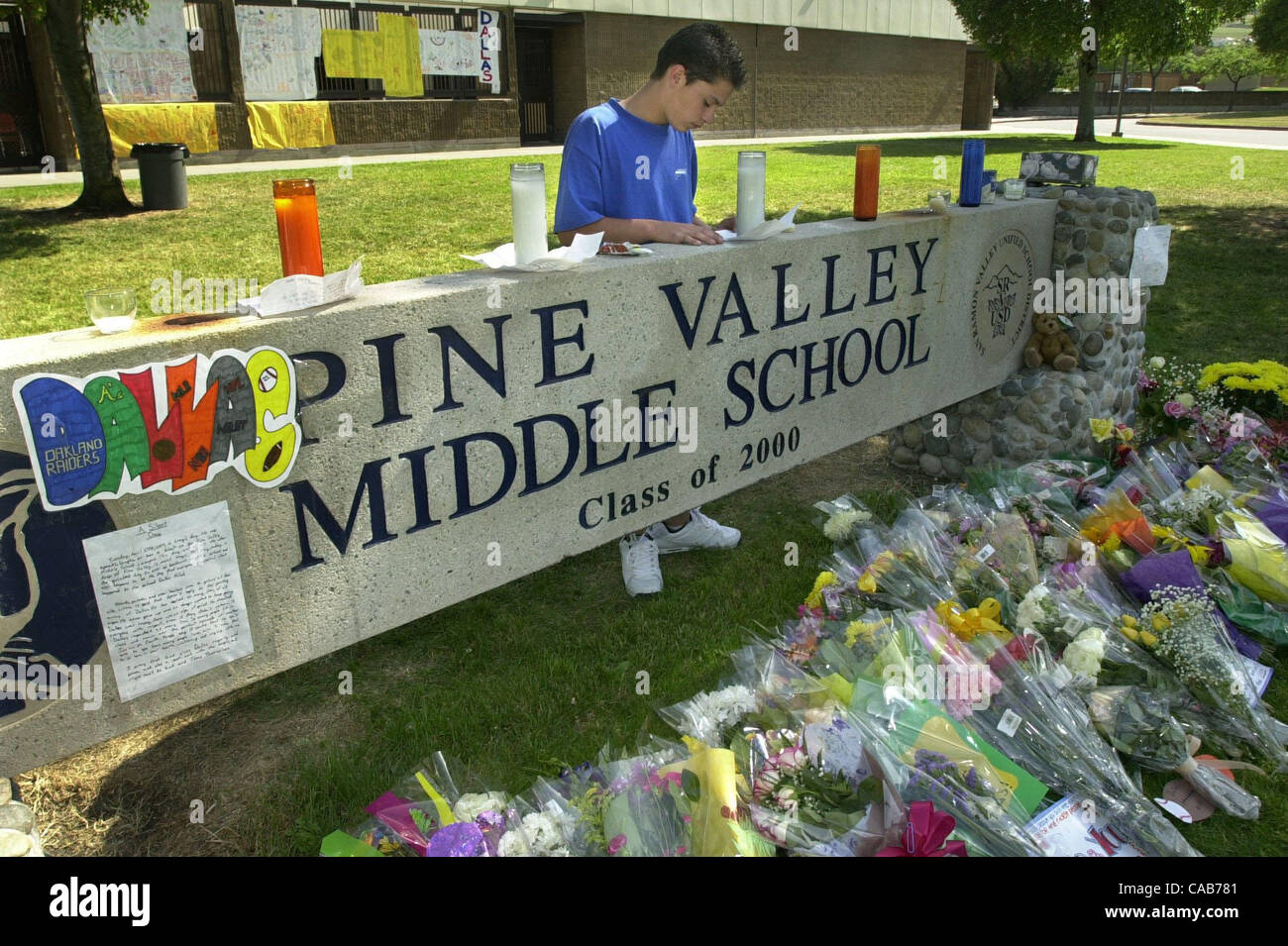 A San Ramon in California, Martedì, 27 aprile 2004, la valle del pino centro scuola studente Ty Montano 15, di San Ramon, California, legge una lettera a sinistra un memoriale per classmate Dallas Milat che è stato ucciso in un solo incidente in bicicletta il lunedì sera. (Contra Costa Times/Doug Duran) Foto Stock