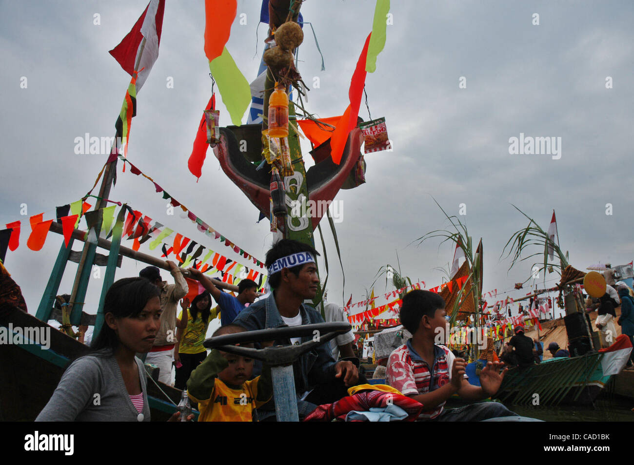 Gli abitanti di un villaggio al villaggio fisheman board sulla barca durante un pescatore alms cerimonia del mare o Tradisi Nyadran nella lingua locale in Marunda periferia di Jakarta, luglio 25, 2010.Tradisi Nyadran è una tradizione della comunità costiere è un simbolo del rapporto con gli antenati, colleghi, Dio e l'universo, come Foto Stock