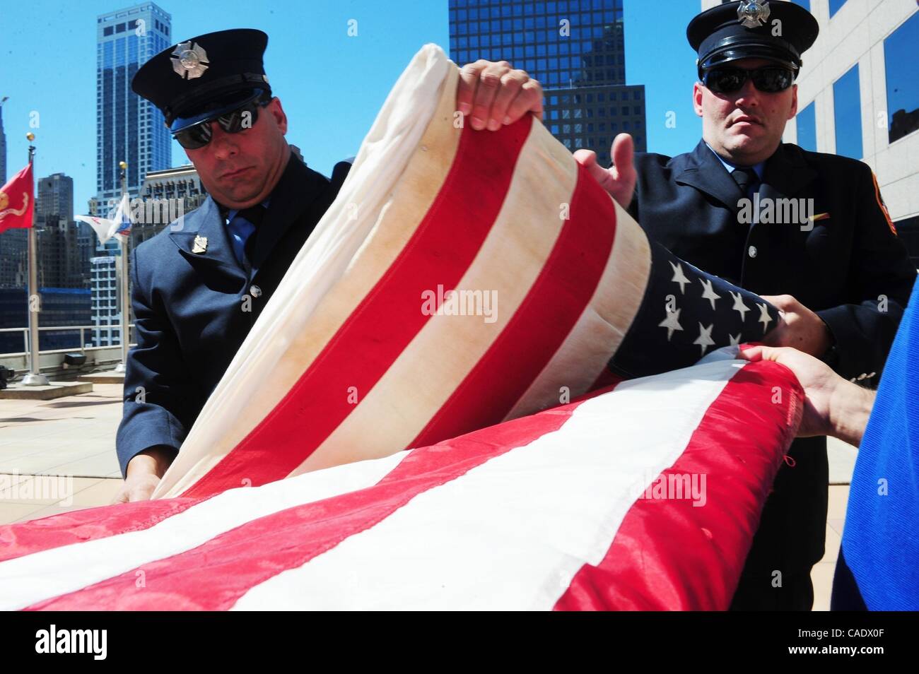 Jul 02, 2010 - Manhattan, New York, Stati Uniti d'America - Vigili del Fuoco Frank Ocello (L) e Jimmy Sands (R) della scala 173 a Howard Beach ripiegare la bandiera. Il New York dice Grazie Foundation (NYSTY) dona il National 9/11 Flag per la National September 11 Memorial & Museum, le organizzazioni a commemorare il Foto Stock