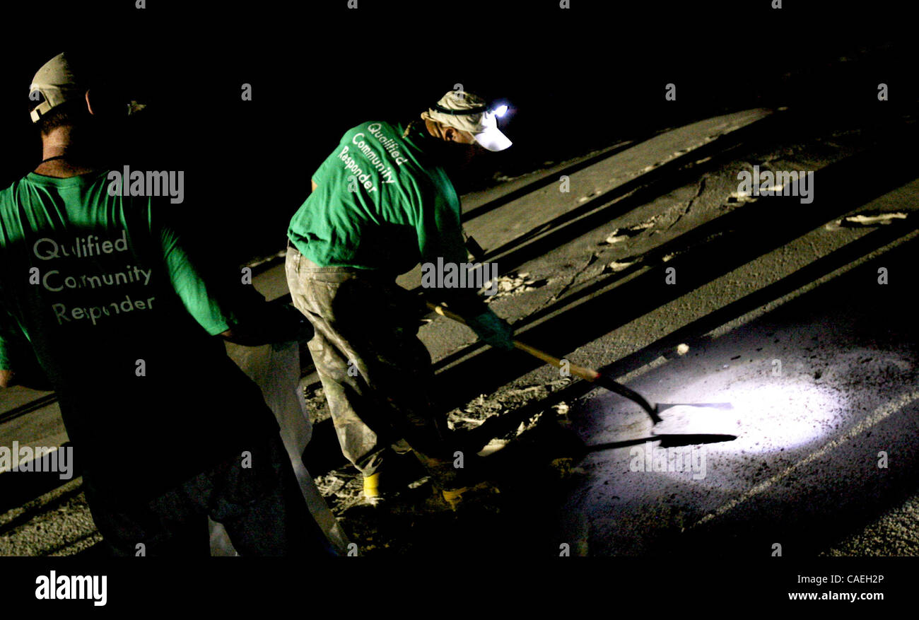 Pulire i lavoratori cercare bit di lavato olio fino a notte su Orange Beach, Alabama USA il 16 giugno 2010. Pulire i funzionari hanno iniziato l'invio di equipaggi di notte a causa di temperature estreme del giorno d'estate. Foto Stock