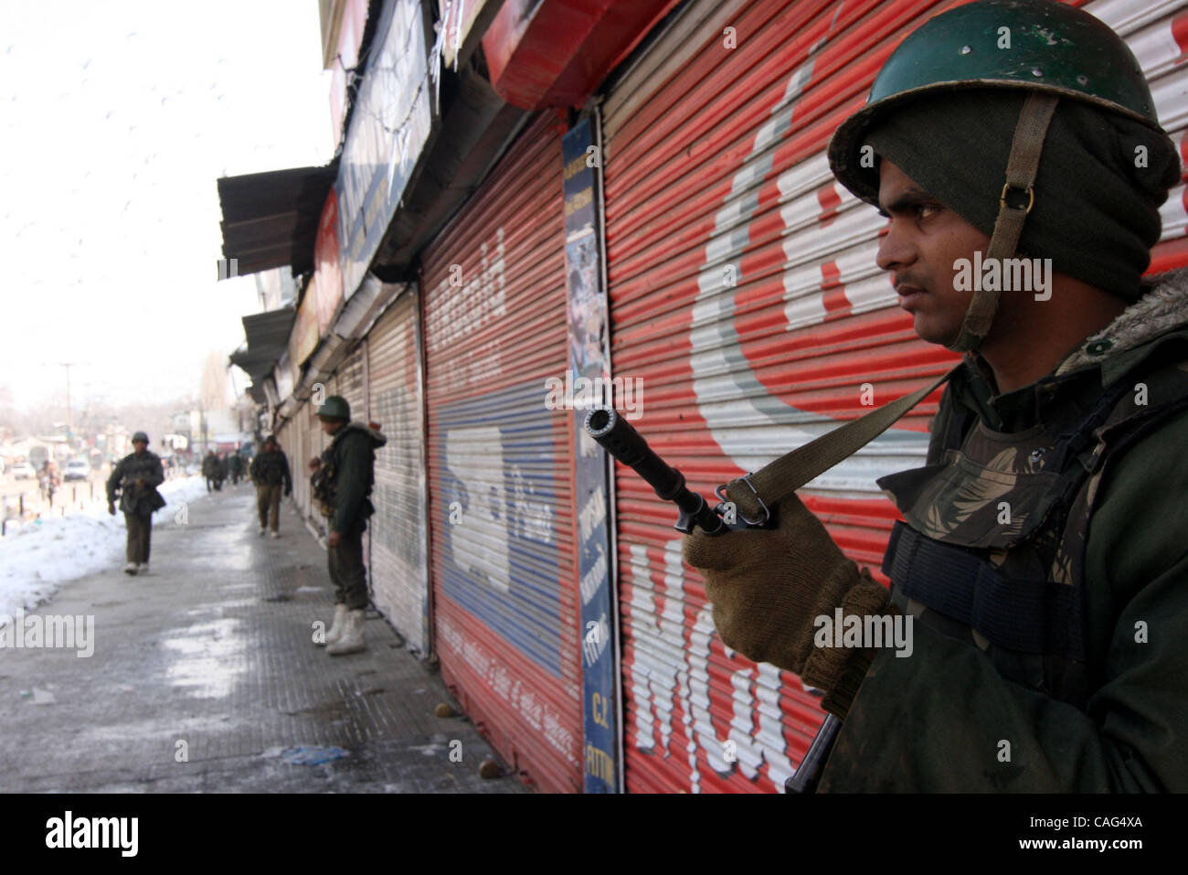 Indiano soldati paramilitari guardia vicino i negozi chiusi in Srinagar il 11 febbraio, 2008. La polizia in Kashmir indiano arrestate decine di dimostranti lunedì impegnativo i resti di Bhat, che fu impiccato e sepolto in un carcere indiano 24 anni fa, la polizia ha detto. Negozi e aziende sono state chiuse i Foto Stock