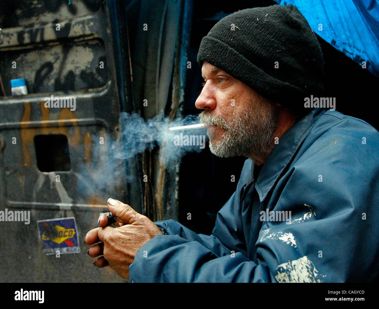 Didascalia foto: 3/6: (Brooksville, Giovedì, 01/24/2008) Grady Moore Jr. prende un fumo e birra pausa mentre seduto in bruciato van egli chiama casa. Moore era uno dei senzatetto locali volontari che ha assistito i gruppi assemblati di prendere un censimento dei senzatetto in est Hernando County su Sa Foto Stock