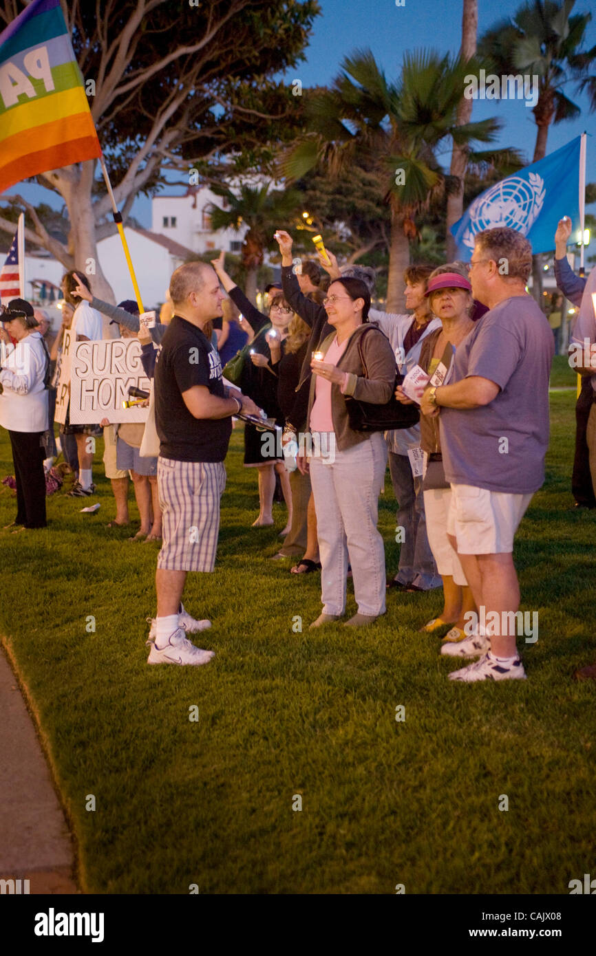 Con striscioni e cartelli, Anti guerra Irag manifestanti si riuniscono per un tramonto "Veglia di pace" nella Laguna Beach, CA. Nota passerby sostenendo con manifestanti. Foto Stock
