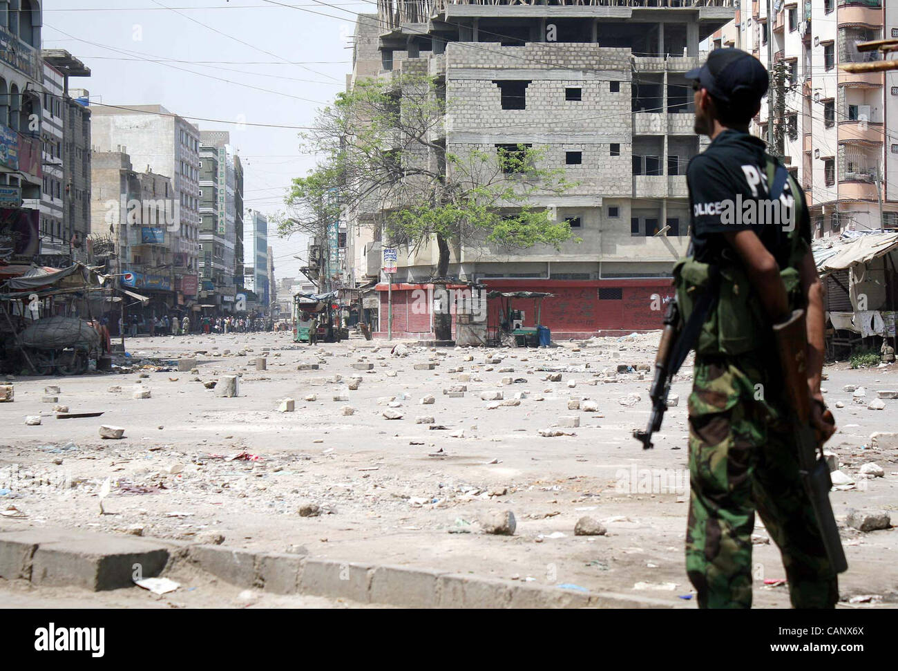 Un poliziotto sta di guardia a pietre ricoperto road come lo scoppio di violenza in area Liyari contro l uccisione di una gioventù in polizia incontro a Karachi il lunedì, 02 aprile 2012. Foto Stock Un poliziotto sta di guardia a pietre ricoperto road come lo scoppio di violenza in area Liyari contro l uccisione di una gioventù in polizia incontro a Karachi il lunedì, 02 aprile 2012. Foto Stock