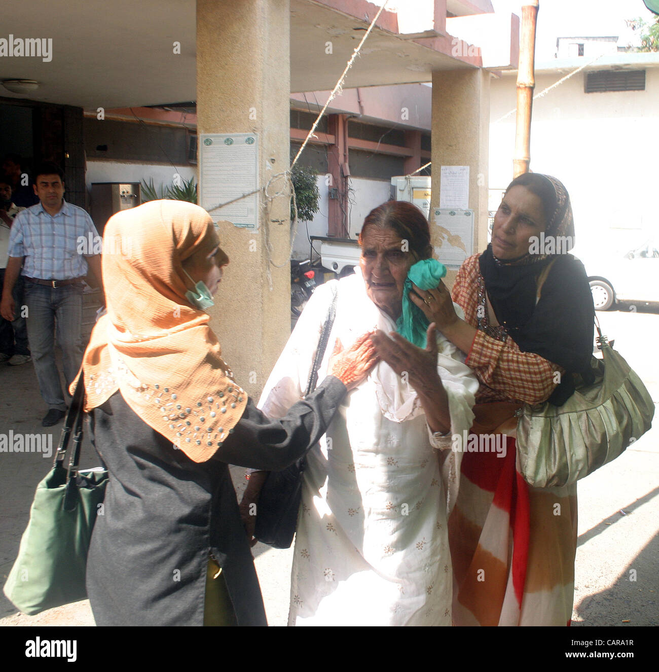 Gli operatori di stand con le loro ferite paziente che è stato ferito durante lo scontro tra le forze di polizia e manifestanti durante la manifestazione di protesta del personale paramedico associazione in favore delle loro richieste a servizi ospedalieri a Karachi il giovedì 12 aprile, 2012. Foto Stock