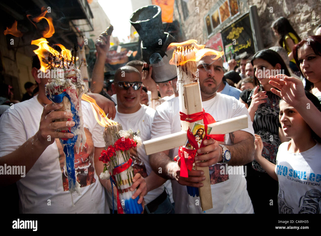 Gerusalemme. Sabato 14 Aprile 2012. Palestinesi cristiani dalla Chiesa Greco Ortodossa marzo con candele e attraversa durante la Pasqua santo rito del fuoco nella Città Vecchia di Gerusalemme Foto Stock