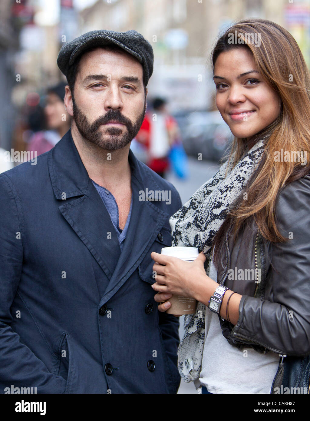 Attore americano e produttore di film Jeremy Piven accompagnato da una bella donna, Brick Lane, London, England, Regno Unito Foto Stock