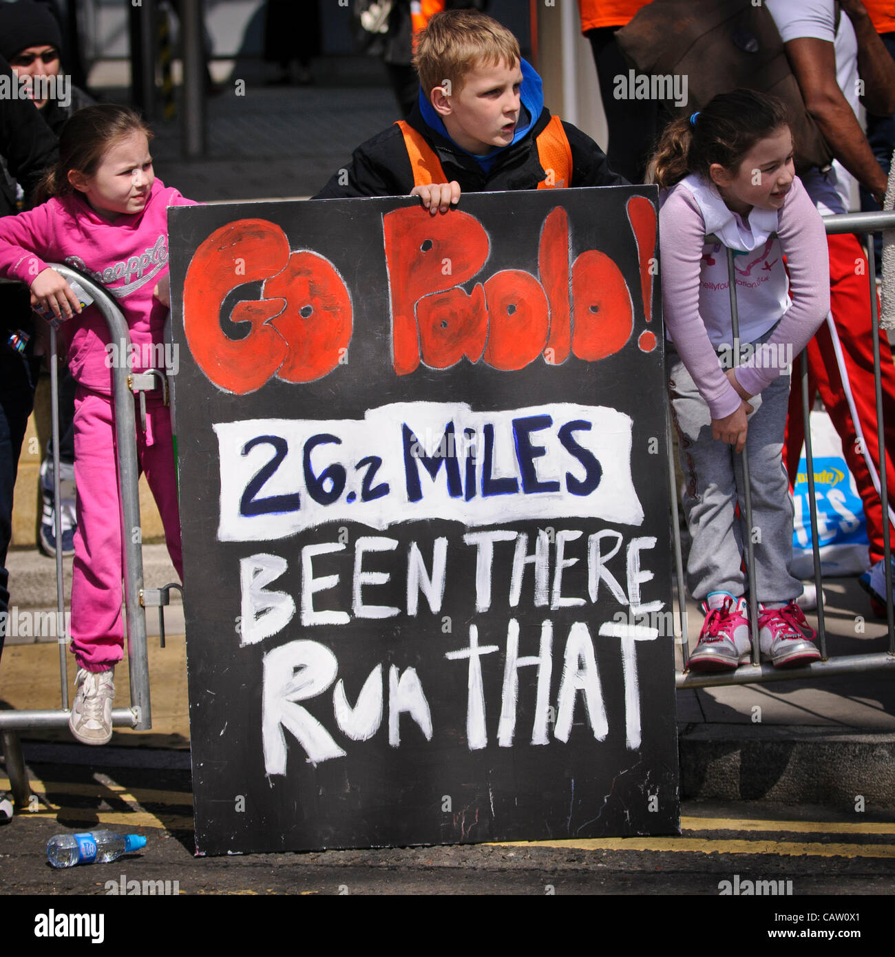 Londra, Canary Wharf, nei pressi di miglio 18, 22 aprile 2012, concorrenti nella maratona di Londra 2012 hanno quasi dieci chilometri in più per andare. Ben wishers dare incoraggiamento ai cari. Foto Stock