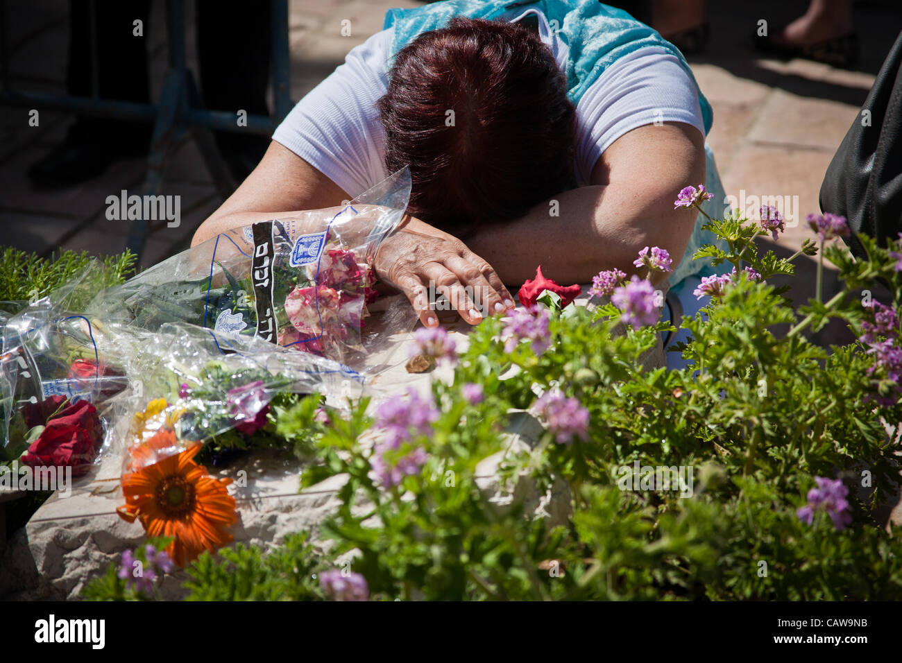 Una madre stabilisce la sua testa nel dolore sulla tomba di suo figlio nella sezione di polizia di Mt. Hertzl cimitero militare. Gerusalemme, Israele. 25-Apr-2012. Foto Stock