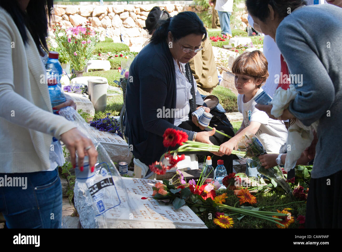 Famiglie porre fiori sulle tombe dei loro cari nella sezione di polizia di Mt. Hertzl cimitero militare. Gerusalemme, Israele. 25-Apr-2012. Foto Stock