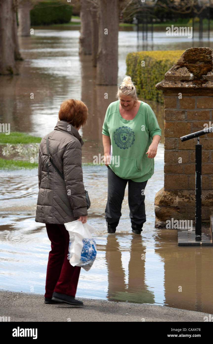 Tewkesbury- Regno Unito - 30 Aprile 2012 - la donna che fa il suo modo attraverso la risalita di acque di esondazione a Tewkesbury, Regno Unito dopo la pioggia. Foto Stock