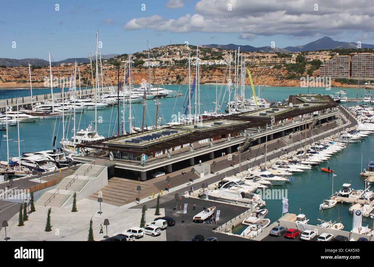 Port Adriano Marina, Calvia, sud ovest di Maiorca, isole Baleari, Spagna. Il 30 aprile 2012. Durante il 'Mallorca Superyacht giorni di evento (28 - 30 Aprile 2012) - panoramica del nuovo centro commerciale comprendente boutique, bar, ristoranti e agenzie di yachting + nuovo superyacht al di là della zona. Foto Stock