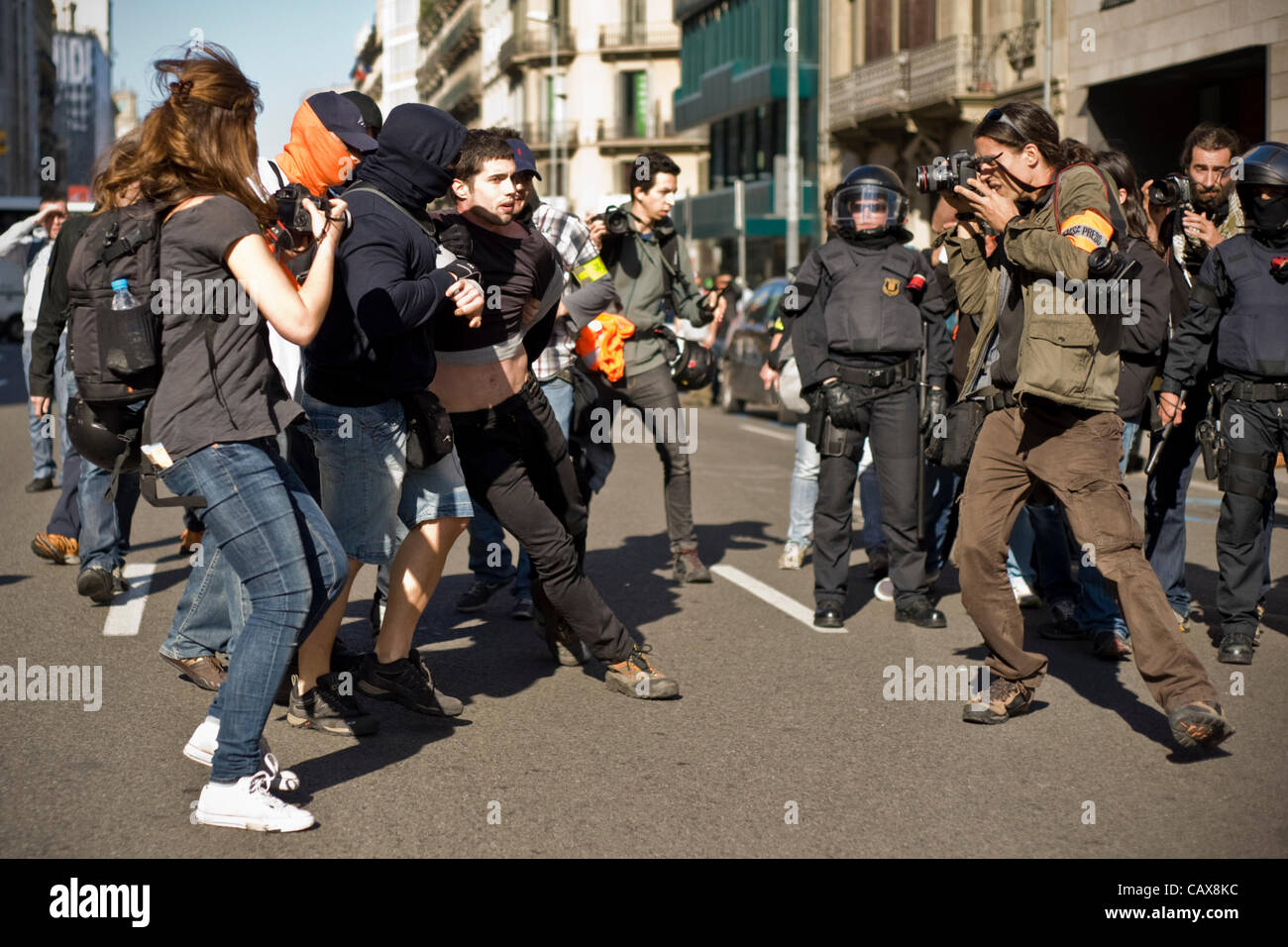 01 maggio 2012- Barcellona, Spagna.mascherato degli ufficiali di polizia di trattenere un manifestante durante la celebrazione delle alternative di dimostrazione di giorno di maggio formata dai sindacati di minoranza e con la presenza di un grande spiegamento di polizia. Foto Stock