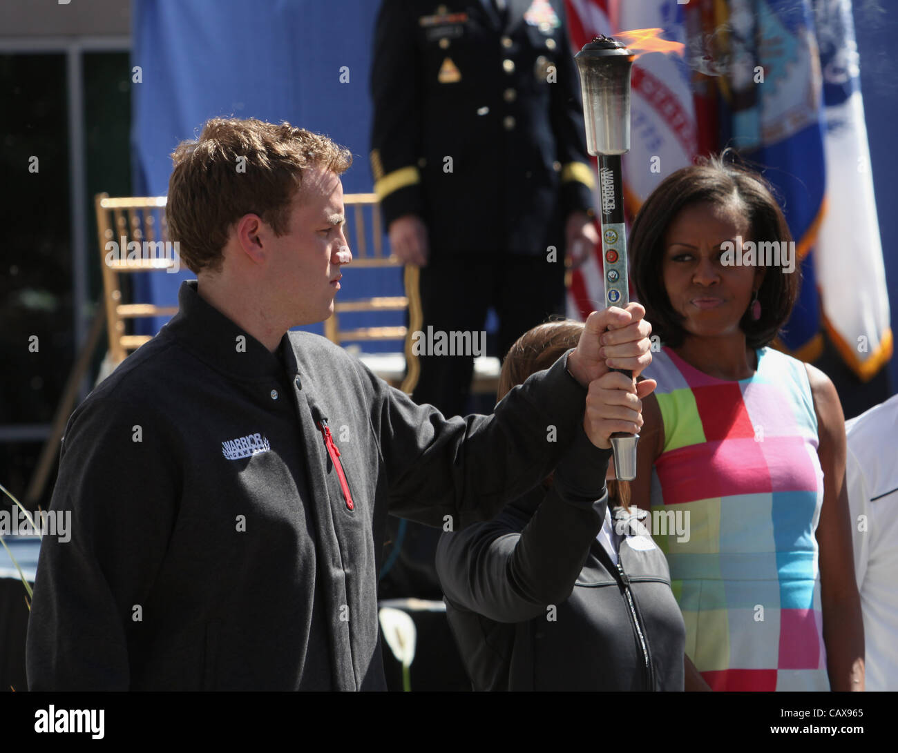 La First Lady Michelle Obama orologi come esercito pensionato veterano Melissa Stockwell e Royal Marine Capt. Simon Maxwell trasportare la torcia durante la cerimonia di apertura dei Giochi del guerriero 2012 Maggio 1, 2012 a Colorado Springs, Colorado. Foto Stock