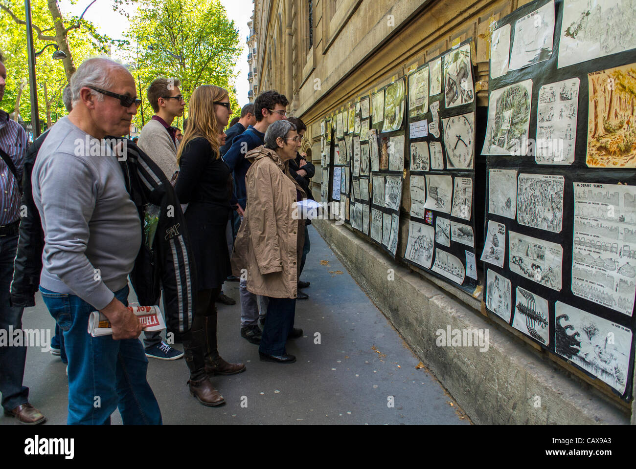 Parigi, Francia, persone che guardano i cartoni politici francesi in mostra sulla Street Wall alla dimostrazione dei sindacati francesi in occasione degli eventi annuali della giornata del lavoro di maggio Foto Stock