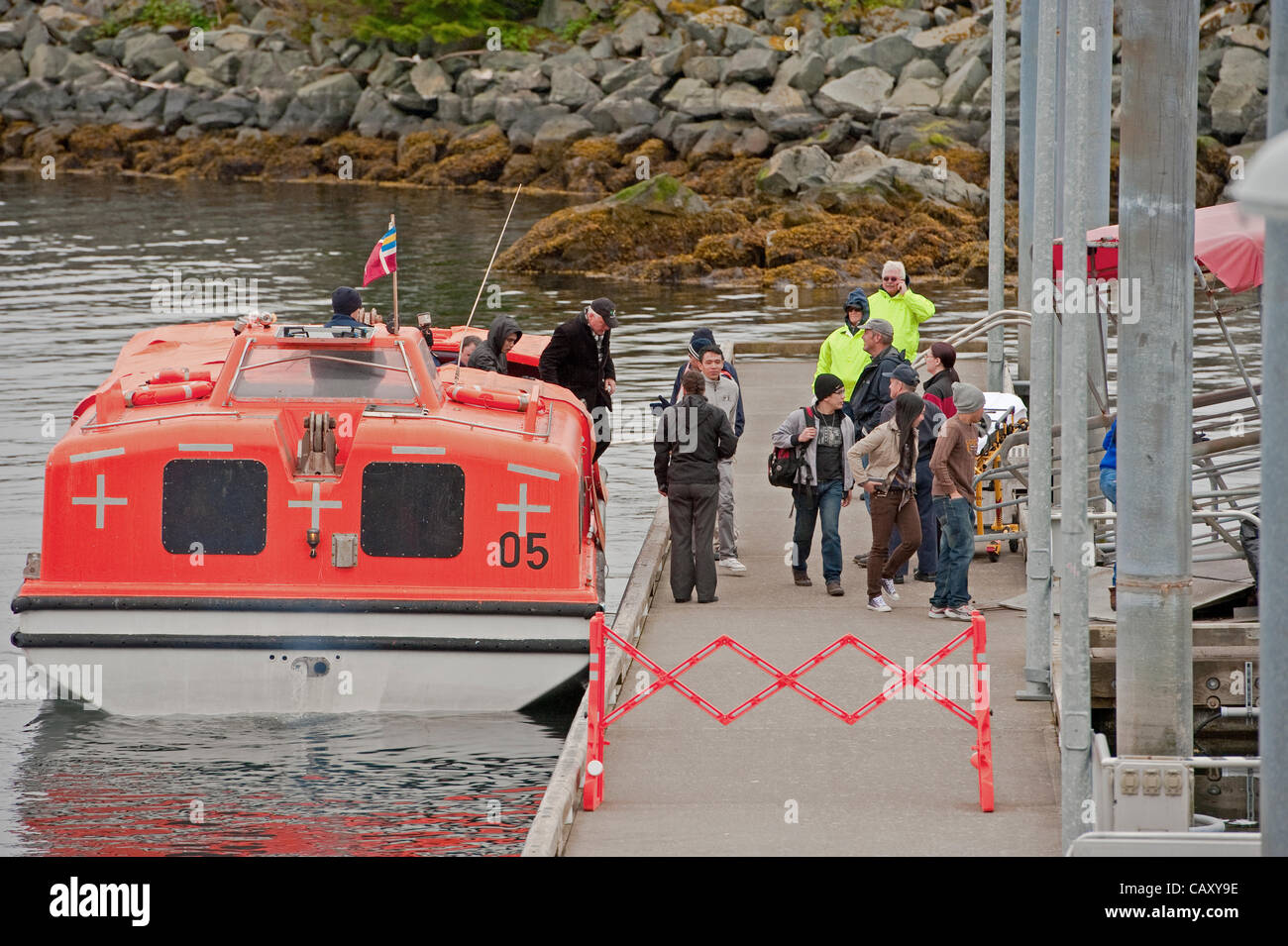 Sitka, Alaska, 5 maggio 2012 la nave di crociera passeggeri e membri di equipaggio scendono dalla nave da crociera più leggeri. Foto Stock