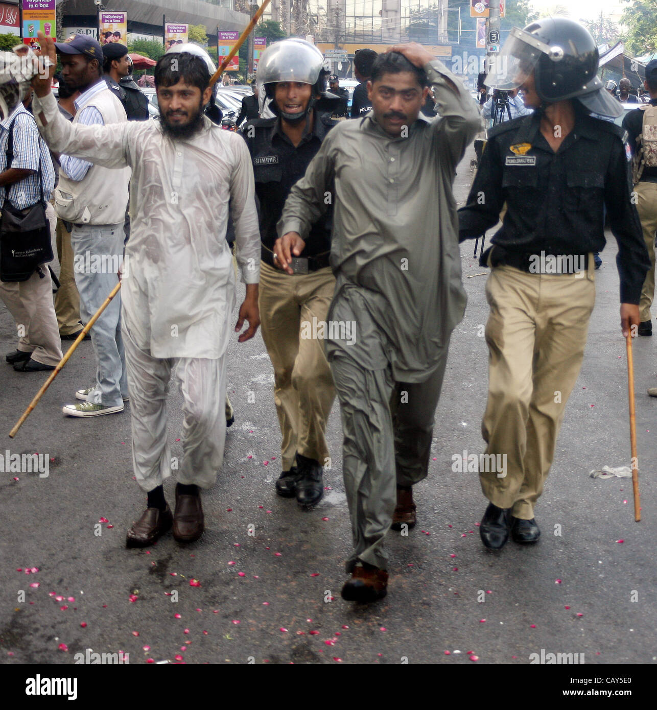 Poliziotti di arrestare i dimostranti durante la manifestazione di protesta della commissione nazionale per lo sviluppo umano (NCHD) dipendenti per i lavori regolari a Karachi il lunedì, 7 maggio 2012. Foto Stock
