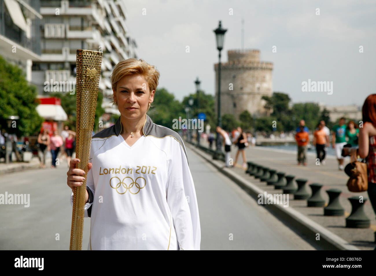 La fiamma olimpica arriva a Salonicco. I torchbearer, Yota Economou accesa l'altare davanti al simbolo della città, la Torre Bianca. Salonicco, Grecia. Maggio 13, 2012. Foto Stock