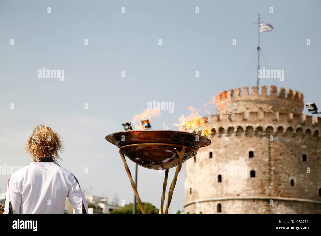 La fiamma olimpica arriva a Salonicco. I torchbearer, Yota Economou accesa l'altare davanti al simbolo della città, la Torre Bianca. Salonicco, Grecia. Maggio 13, 2012. Foto Stock