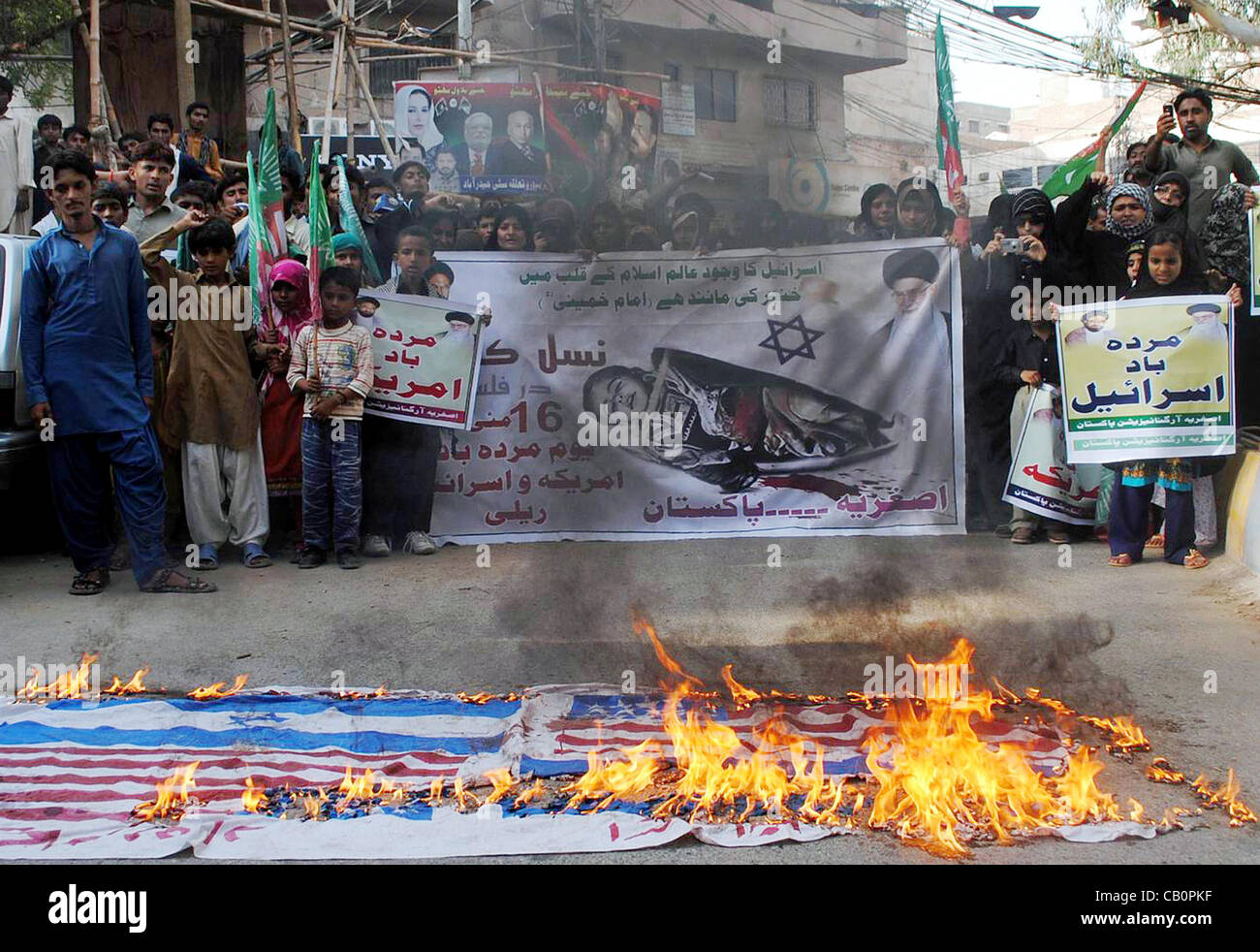 I sostenitori di Asgharia Organizzazione degli studenti (ASO) stand vicino bruciando bandiere come stanno protestando contro Israele in Hyderabad Mercoledì, 16 maggio 2012. Foto Stock