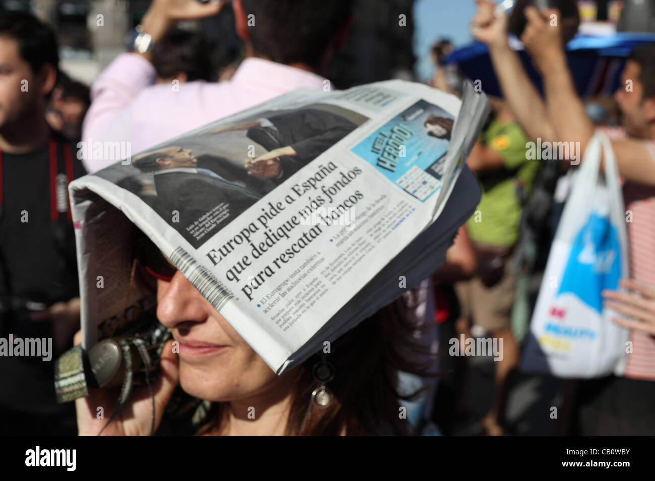 Madrid, Spagna. Una donna stessa protezioni dal sole con un quotidiano durante il primo anno anniversario protesta della Spagna del movimento Indignado il 15 maggio 2012. Simili proteste si sono tenute in tutto il mondo in risposta al movimento spagnolo un anno fa. Foto Stock