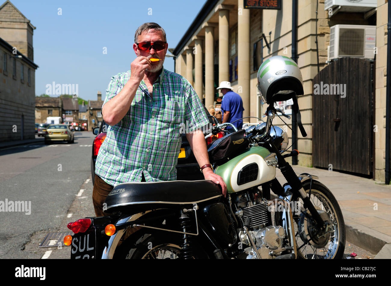Bakewell,UK.23 Maggio,2012.John Lomas mantiene fresco nel calore di un gelato e di un giro fuori sul suo trionfo motocicletta. Foto Stock