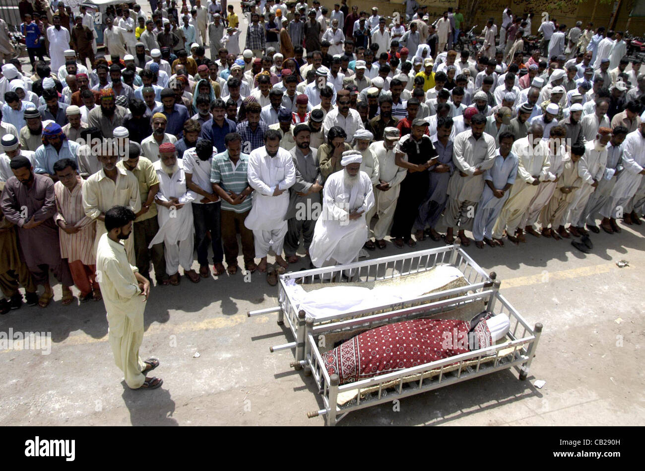 I popoli offrendo preghiere funebri delle persone che hanno perso la loro vita nella cottura incidente su Awami Tahreek Rally, a Chakiwara Chowk a Karachi Mercoledì 23 Maggio, 2012. Foto Stock