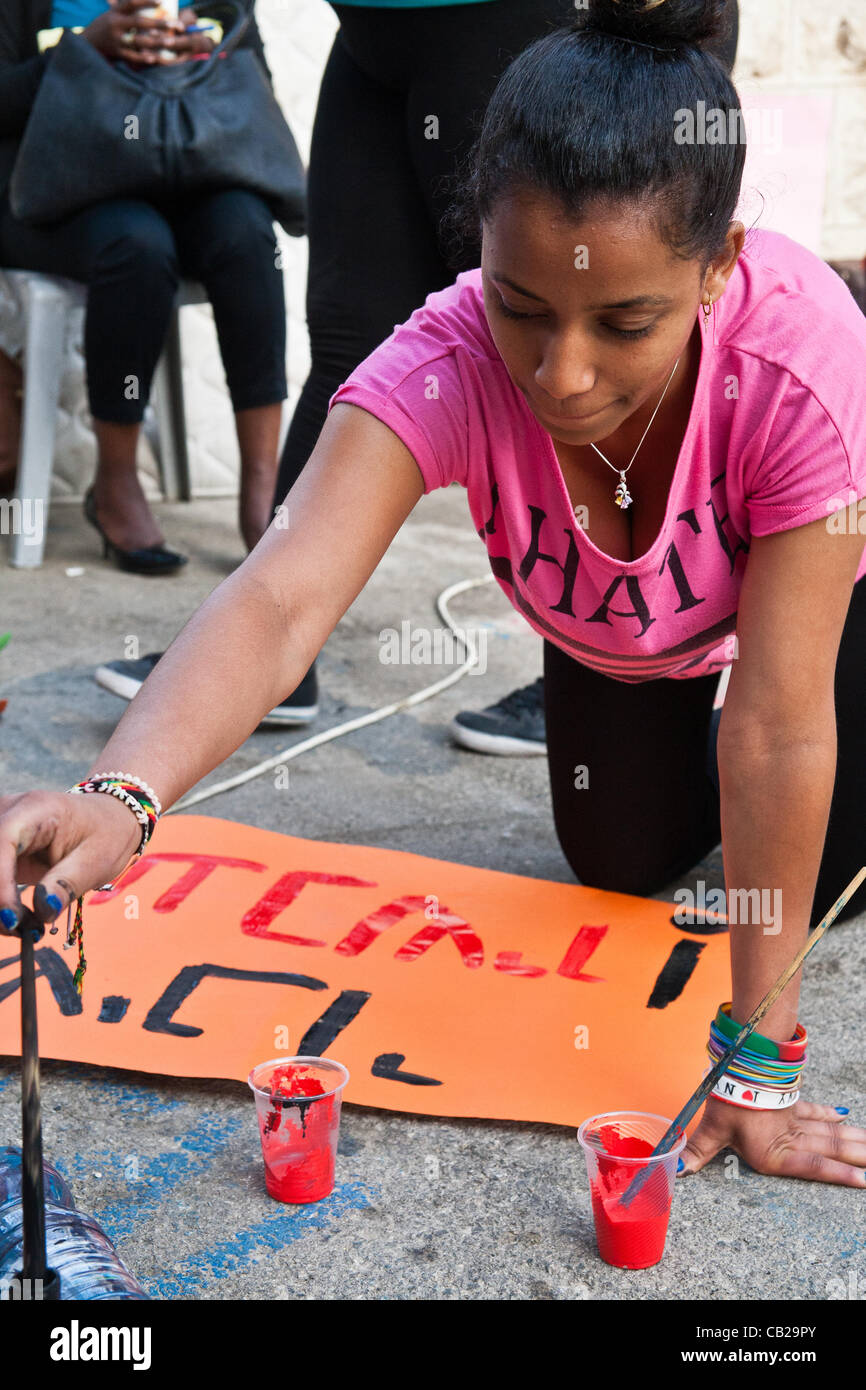 Una giovane donna etiope vernici segni in preparazione per una manifestazione contro la discriminazione razziale nei pressi del PM's residence. Gerusalemme, Israele. 23-Maggio-2012. Foto Stock