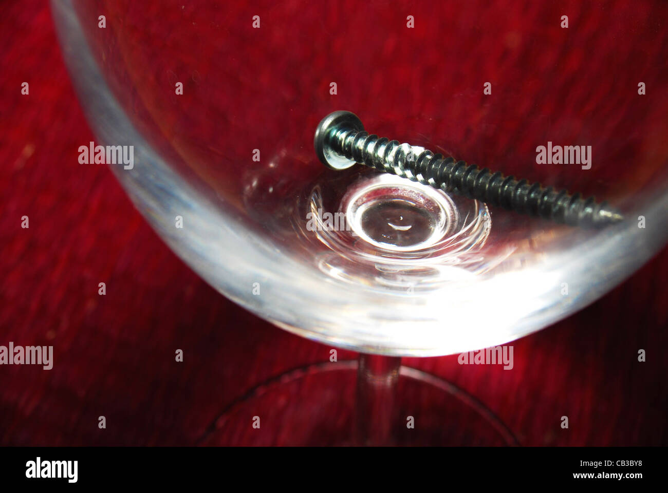 La vite in un bicchiere di vino sulla parte superiore di un posto rosso mat Foto Stock