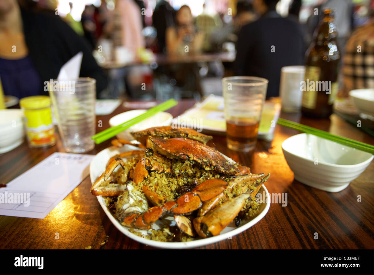 Piastra del granchio piccante cucina a base di pesce a una tabella in un mercato all'aperto di Temple Street cafe di notte kowloon hong kong cina della RAS di Hong Kong Foto Stock