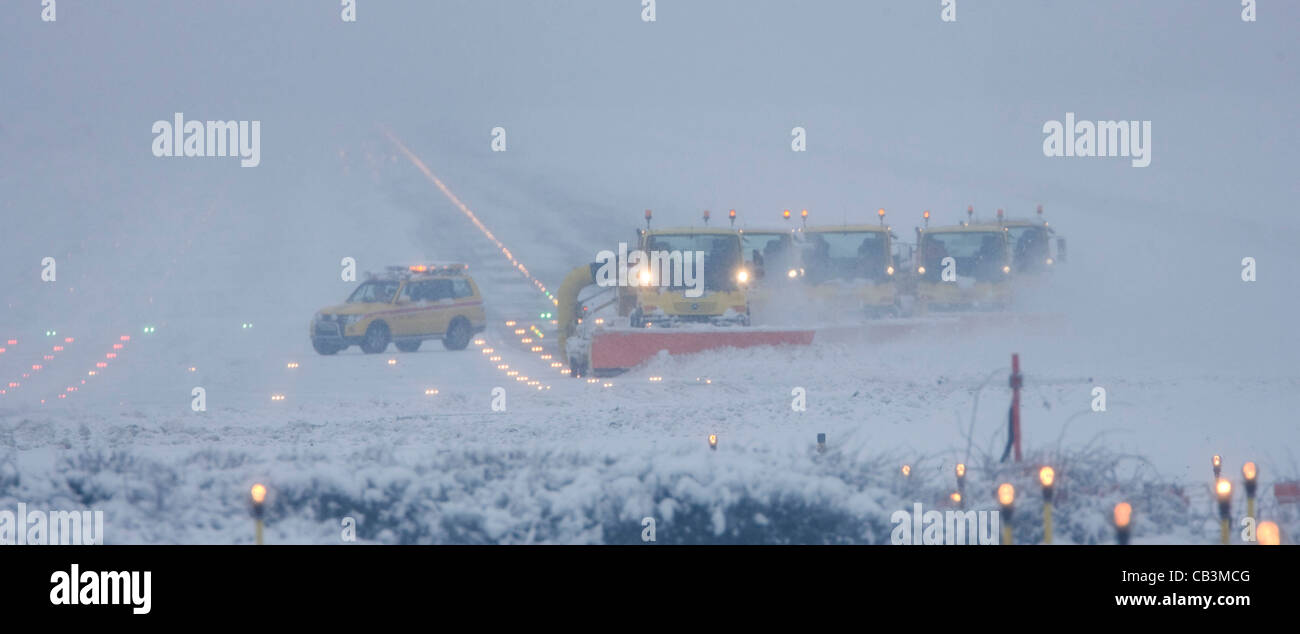 Spazzaneve battaglia per cancellare neve spessa dall'Aeroporto Gatwick di Londra la pista durante una bufera di neve. Foto Stock