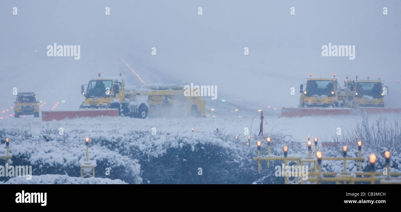 Spazzaneve battaglia per cancellare neve spessa dall'Aeroporto Gatwick di Londra la pista durante una bufera di neve. Foto Stock