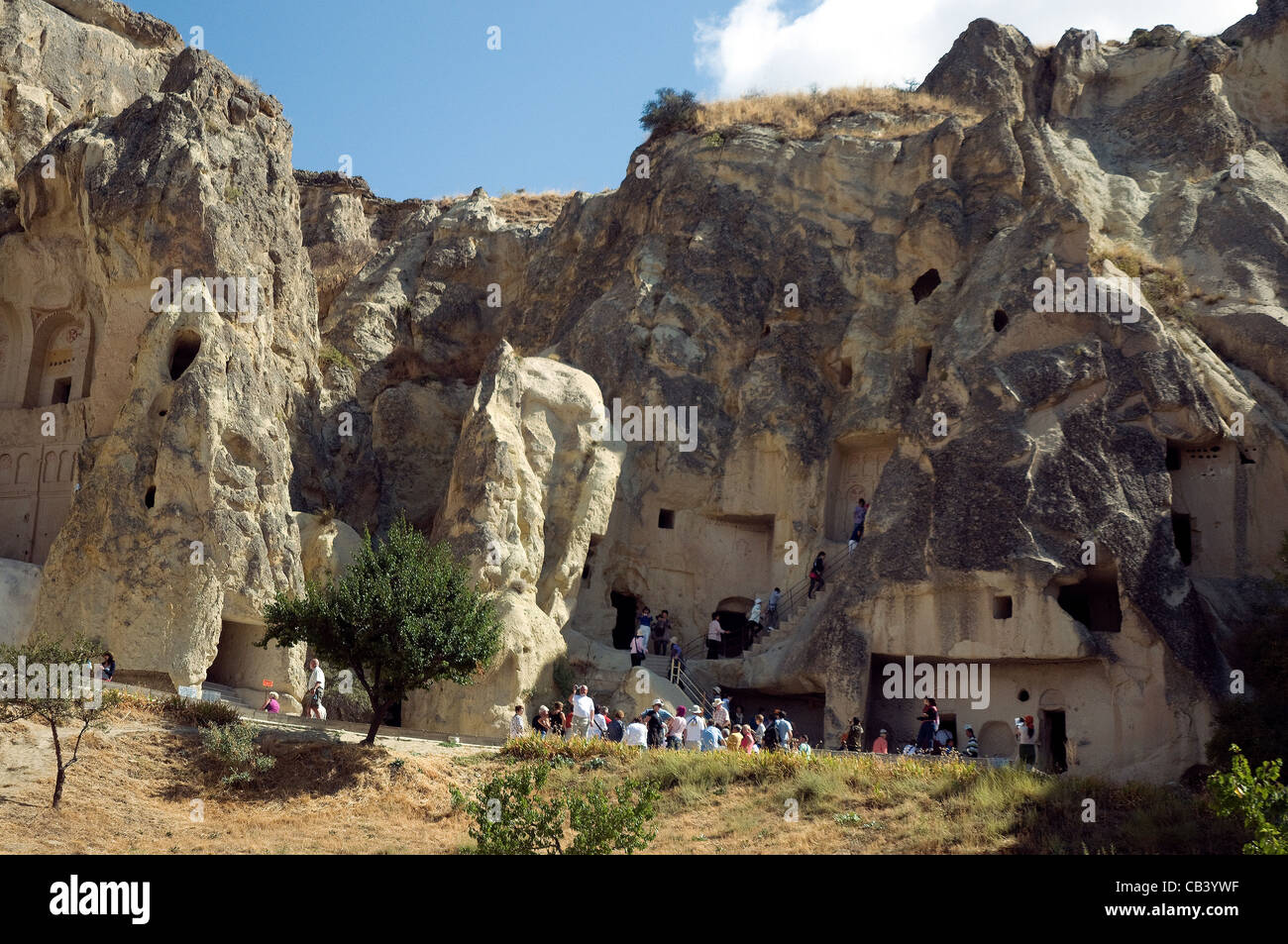 I turisti esplorano il Goreme Open Air Museum's volcanically formate formazioni di roccia, grotte e chiese in Cappadocia Foto Stock