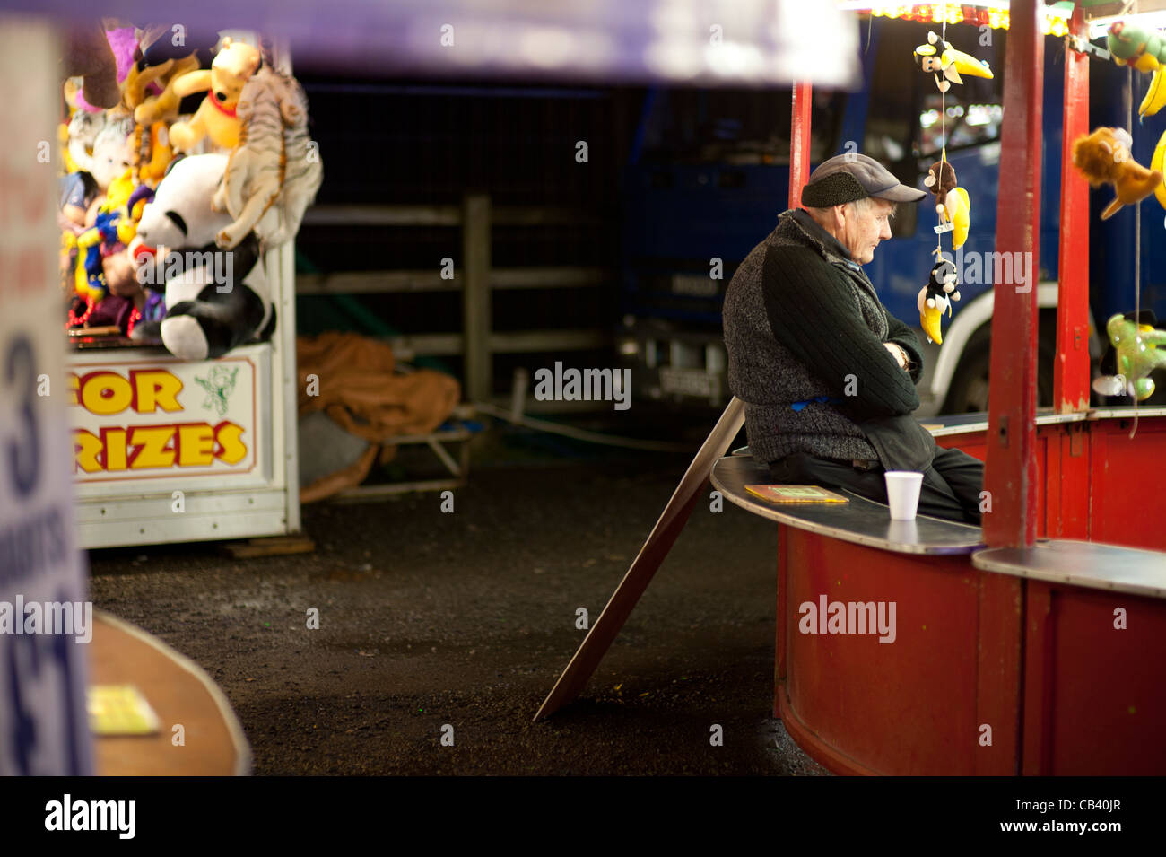 Un Stallholder cercando lavoro annoiato a Aberystwyth annuale di novembre luna park fiera Fiera, Wales UK Foto Stock