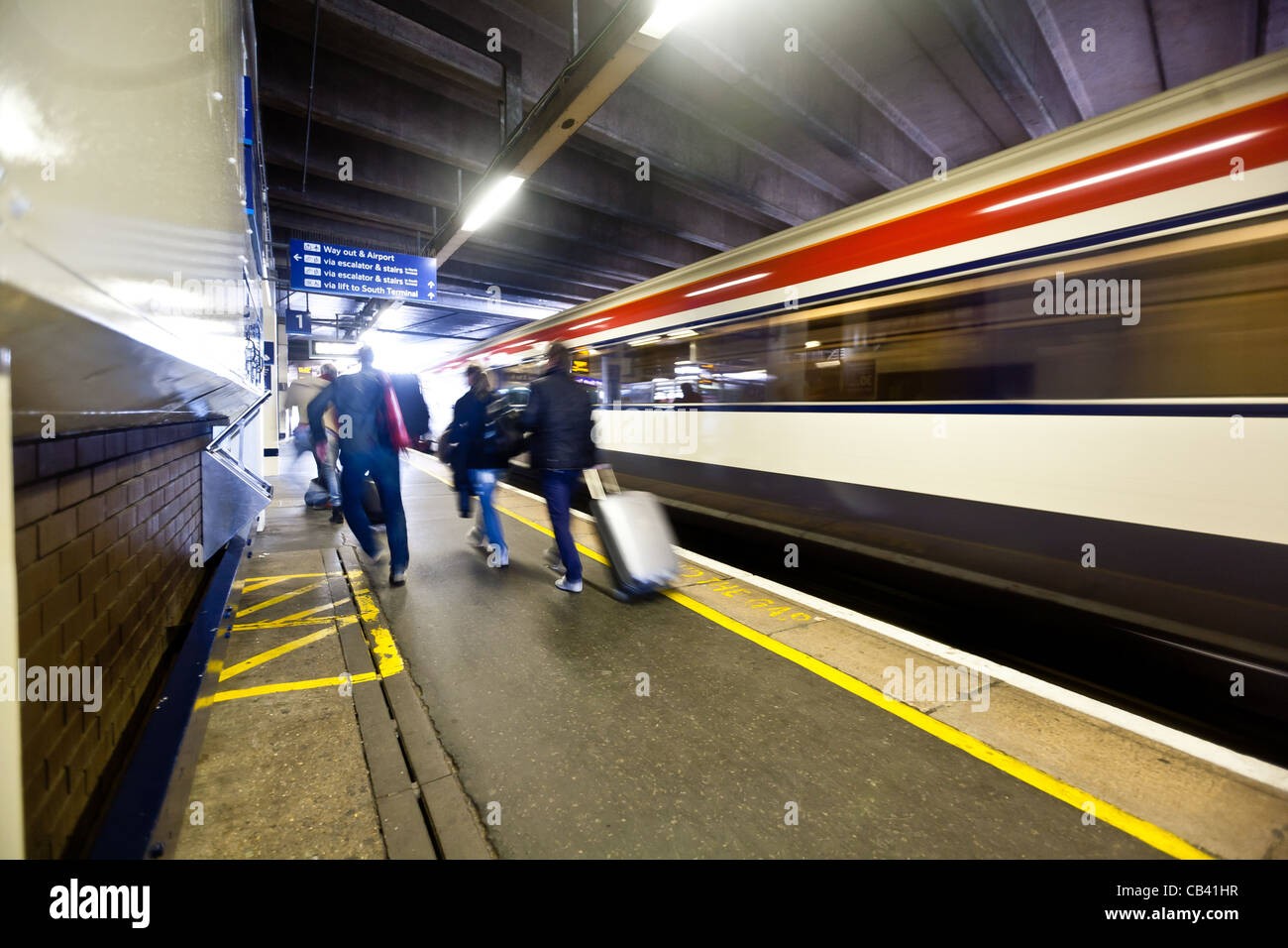 Il gatwick express di lasciare l'aeroporto di Gatwick bound per la stazione di London Victoria. Con i passeggeri a piedi passato. Foto Stock