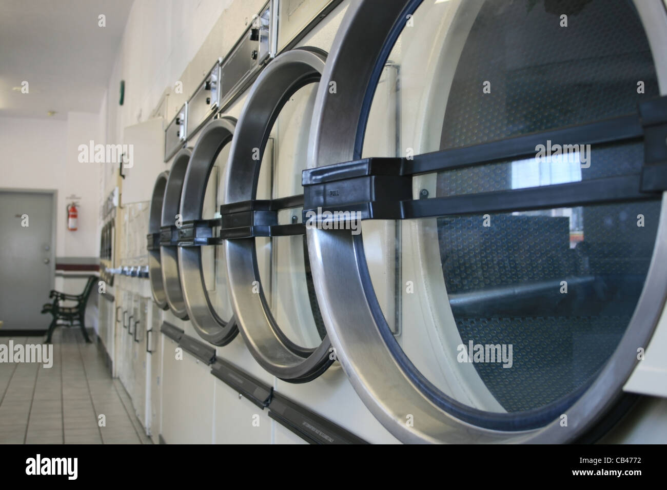 Una fila di lavanderia commerciali le macchine di asciugatura a una lavanderia a gettoni Foto Stock