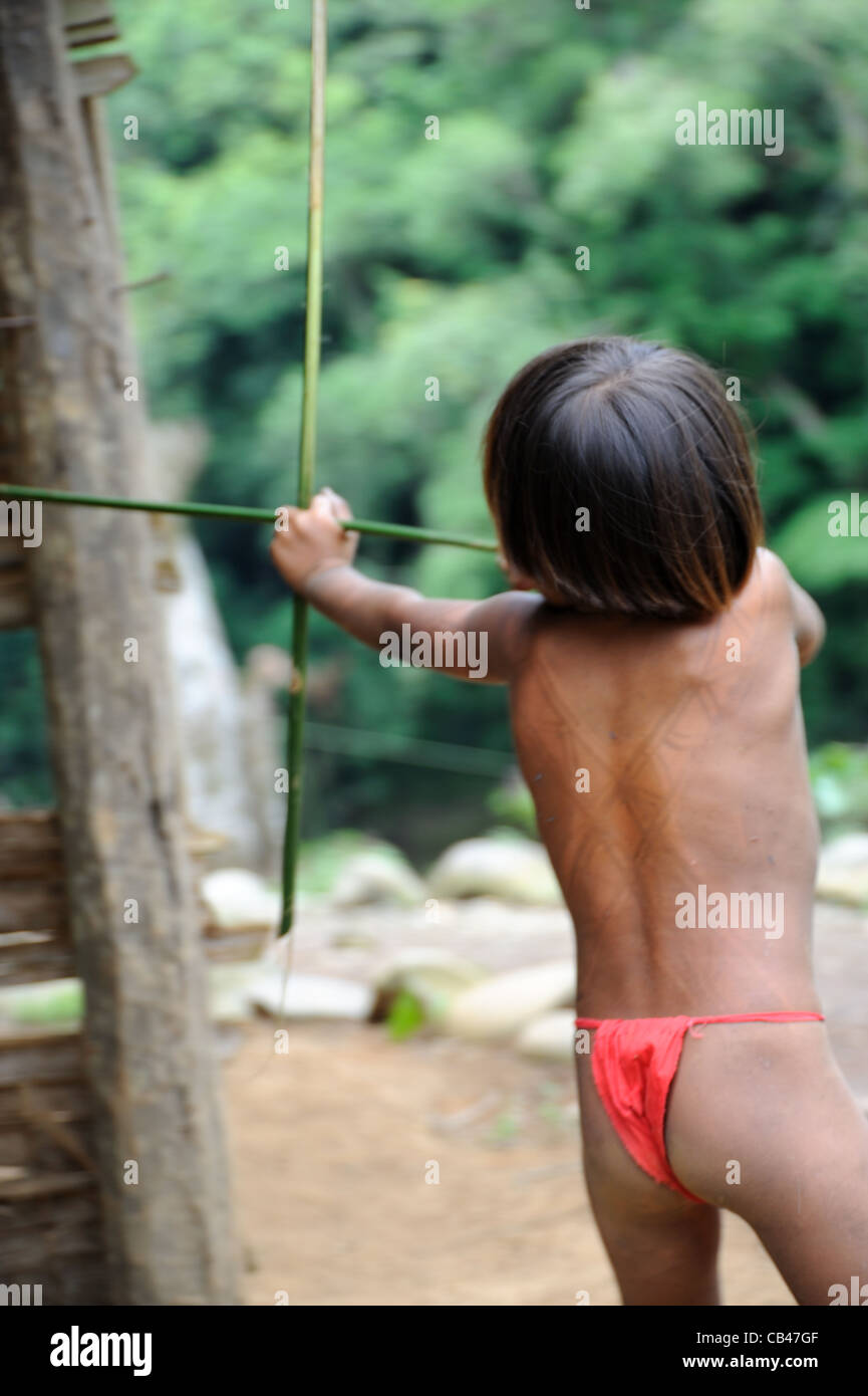 Il ragazzo nativo di Embera che gioca a caccia con arco e freccia presso la comunità indigena Embera Puru a Panama, Foto Stock