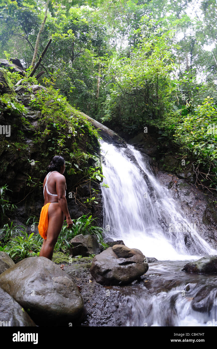 L'uomo indiano di Embera in una cascata del fiume Chagres presso la comunità indigena di Embera Puru nella foresta ombrofila di Panama. Foto Stock