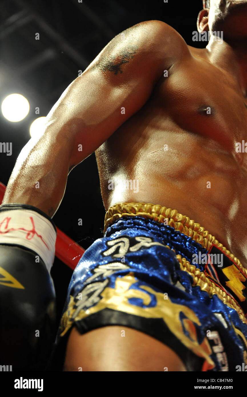 Muay combattente tailandese durante un combattimento di arti marziali di boxe thailandese. Foto Stock