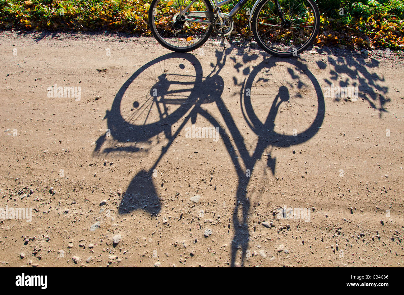 In piedi in bicicletta e in ombra sulla strada di ghiaia. Foto Stock