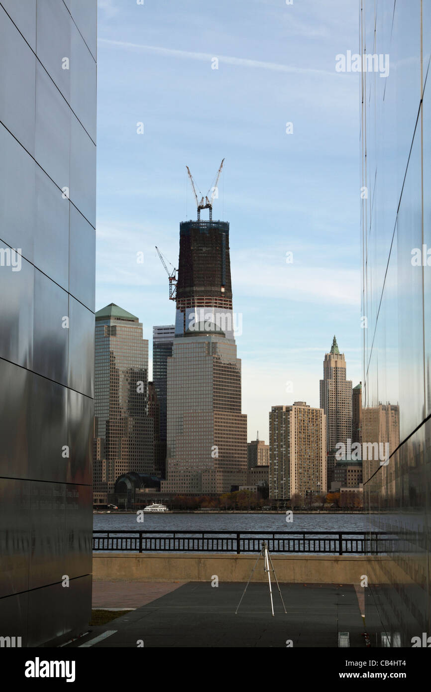 Vista della Torre di libertà in costruzione a Ground Zero incorniciato dalle pareti del cielo vuoto Memorial a Liberty State Park Foto Stock